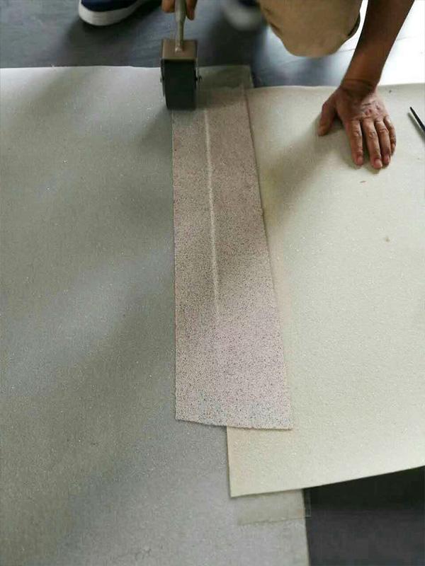 Application of sand cover strip